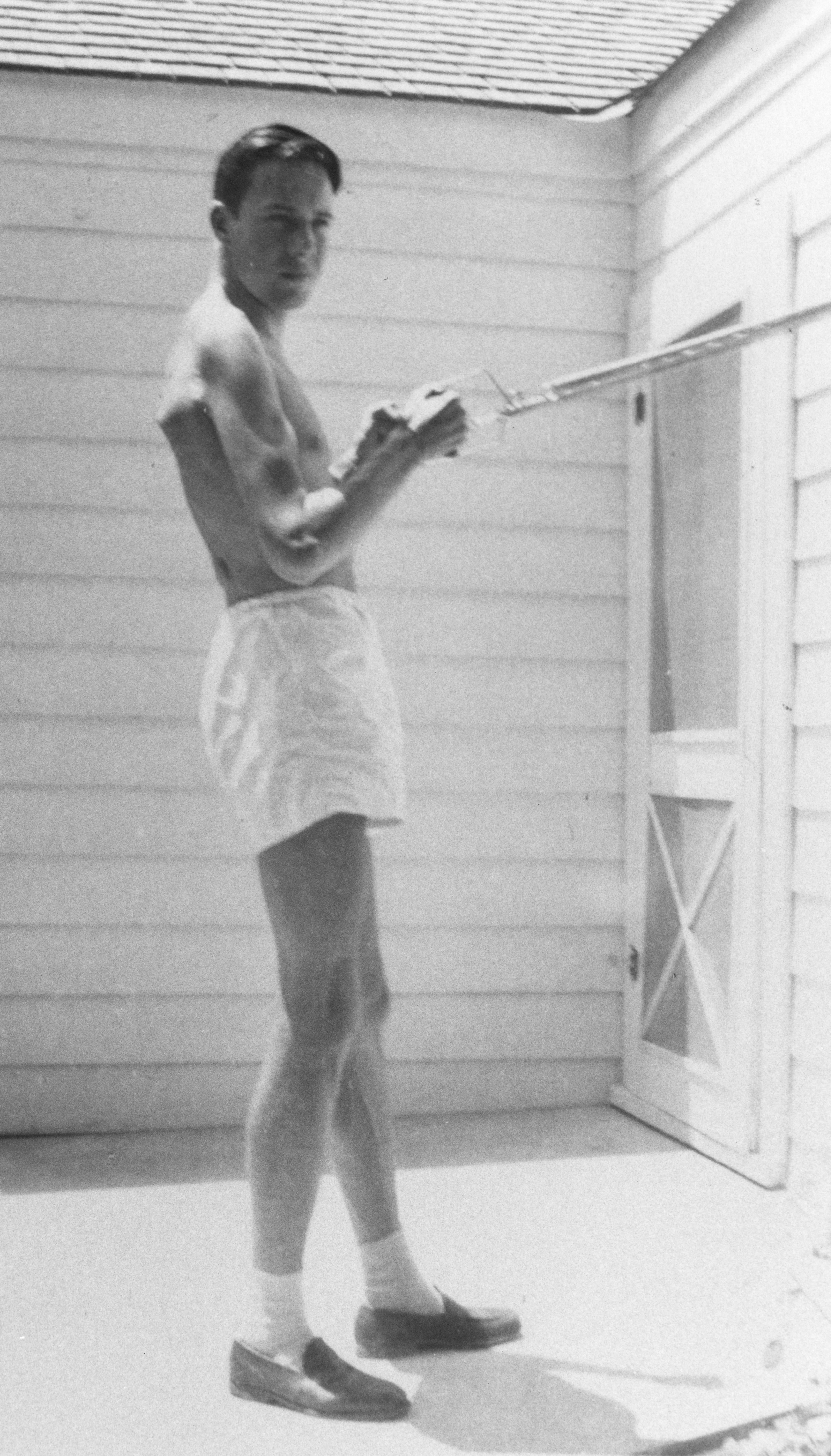 A person in shorts holding handles attached to a taut rope